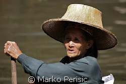 Portrait of a fisher woman making her way in a dug out boat. by Marko Perisic 